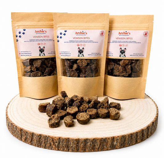 Vension bites dog treats in resealable pouches with natural training treats displayed on wooden log