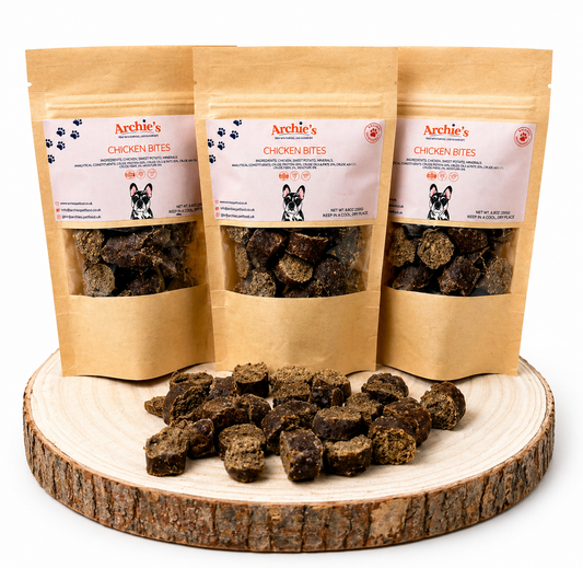 Chicken bites dog treats in resealable pouches with natural training treats displayed on wooden log