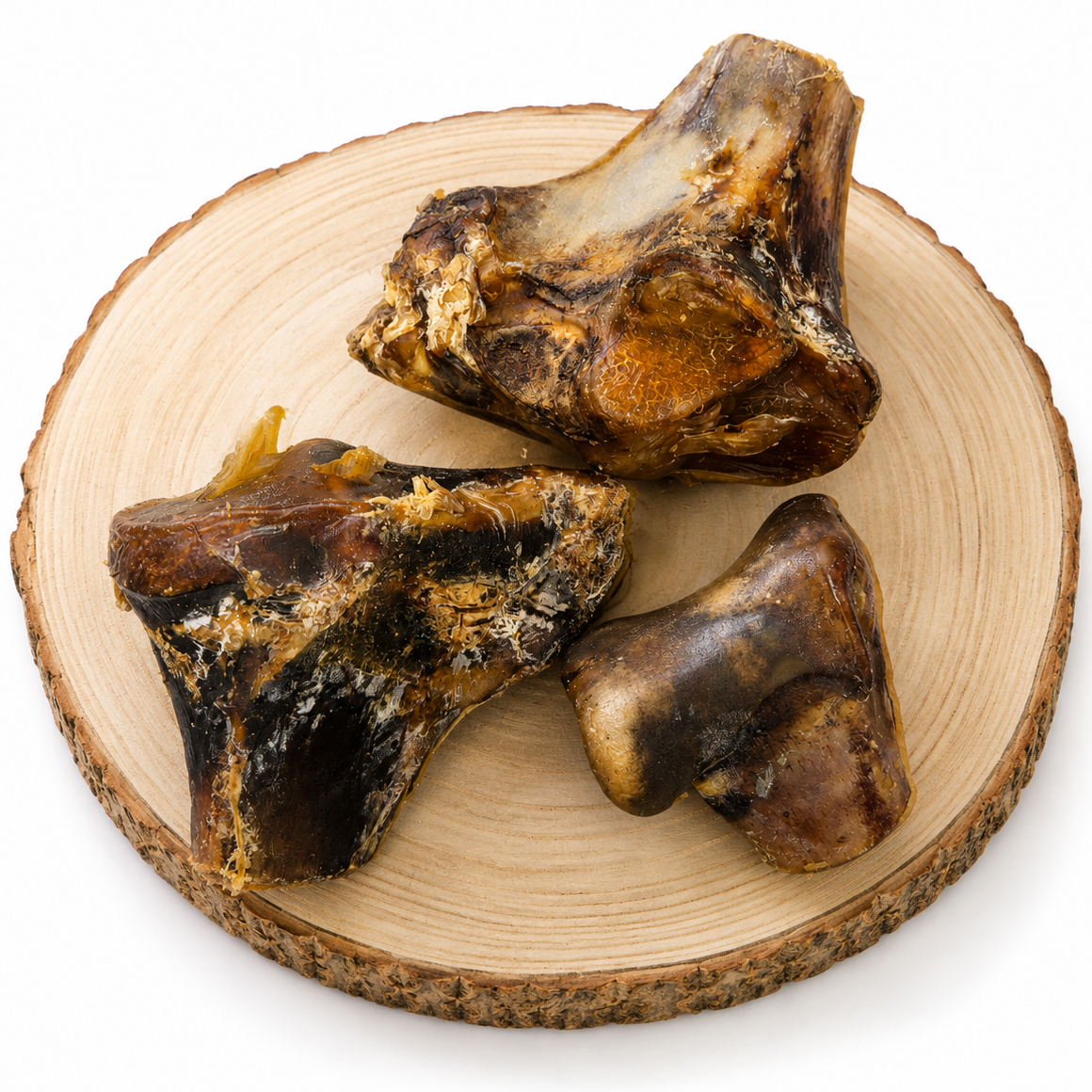 Small and large ostrich knuckle dog treats on a wooden log.