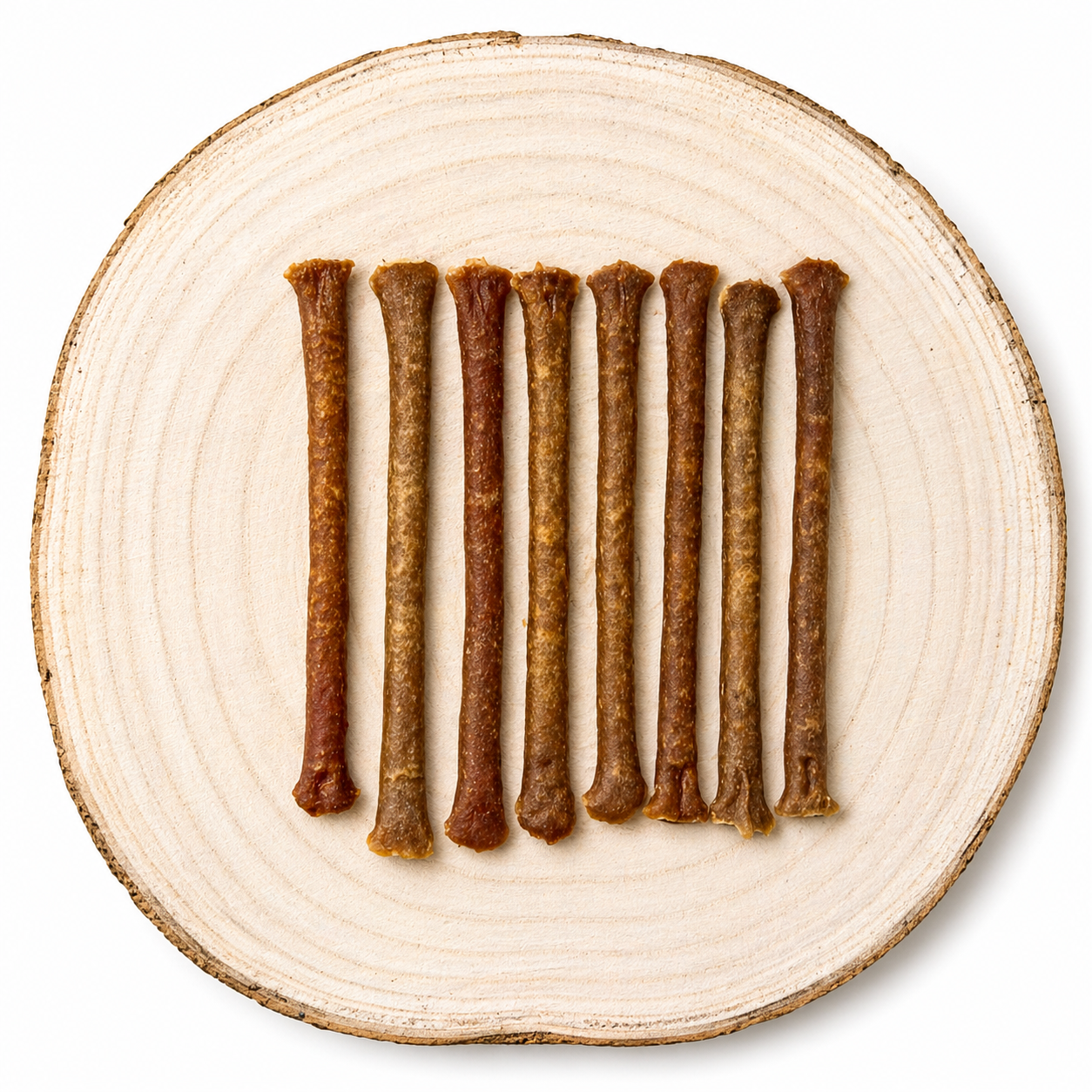 Natural Ostrich meaty dog treat sticks displayed in a row on a natural wooden slice.