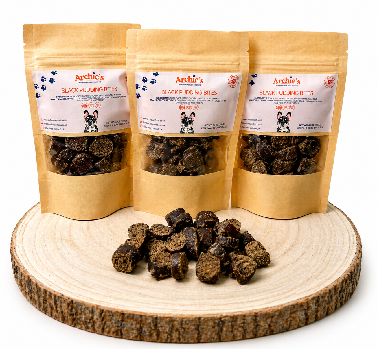 Black pudding bites dog treats in resealable pouches with natural training treats displayed on wooden log.