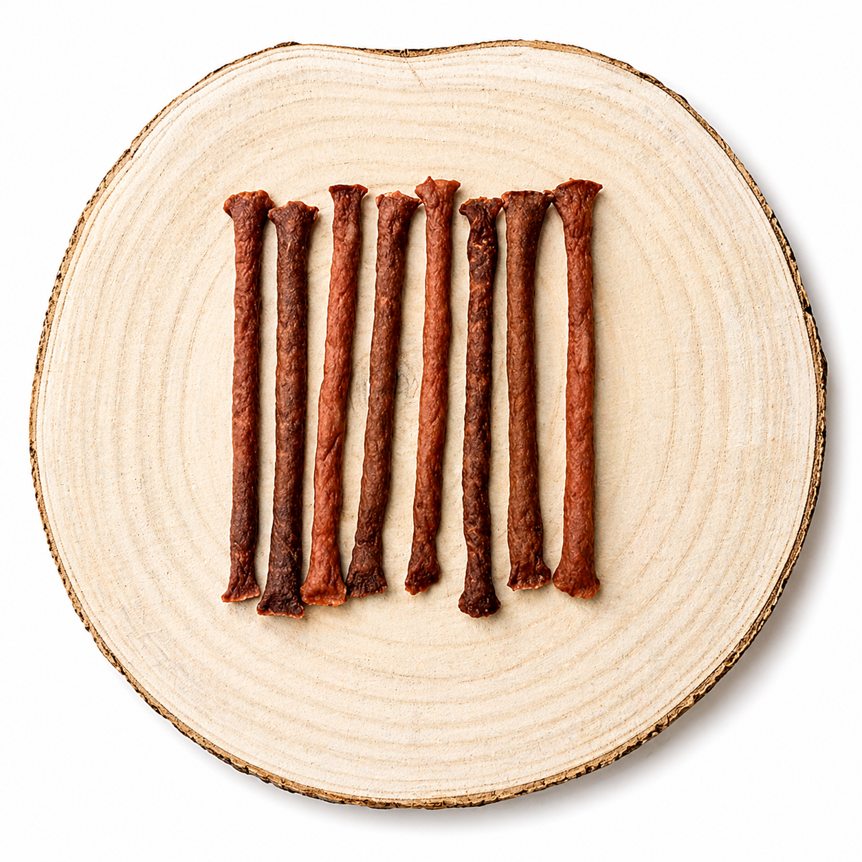 Natural Duck meaty dog treat sticks displayed in a row on a natural wooden slice.