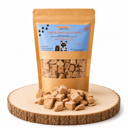 Freeze dried duck dog and cat treats displayed on a wooden log.