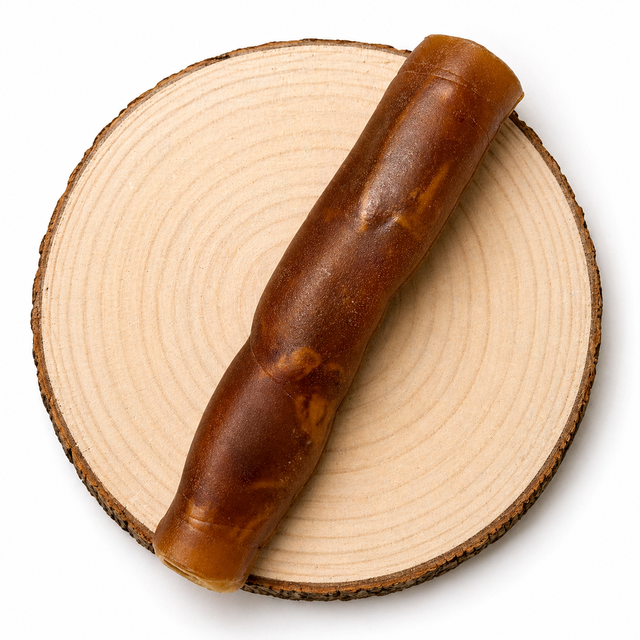 Jumbo camel roll dog treat on a wooden log.
