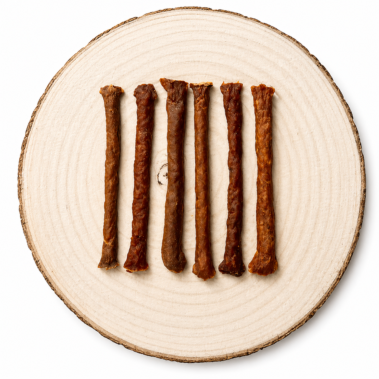 Natural Kangaroo meaty dog treat sticks displayed in a row on a natural wooden slice.