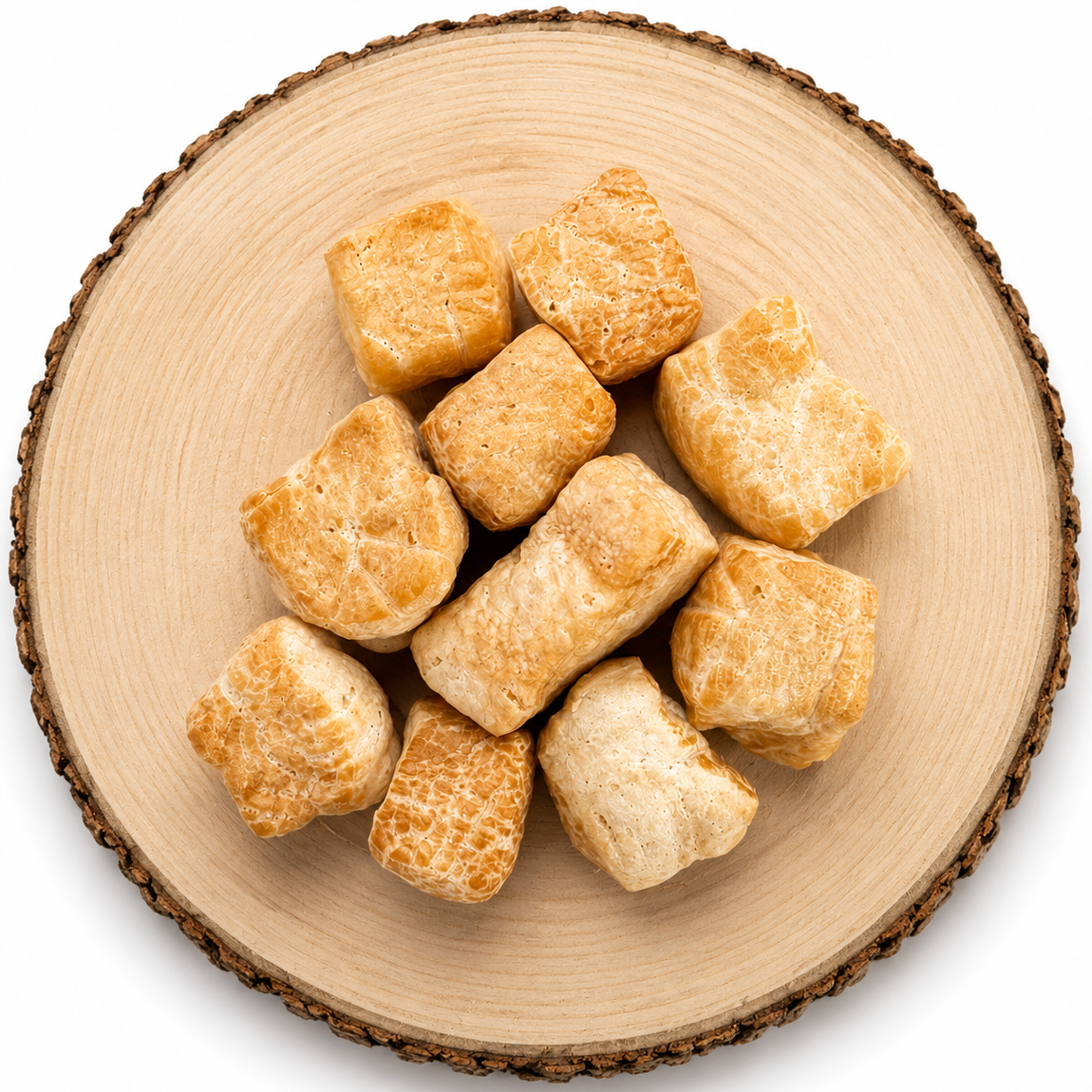Original yak puff dog treats on a wooden log.
