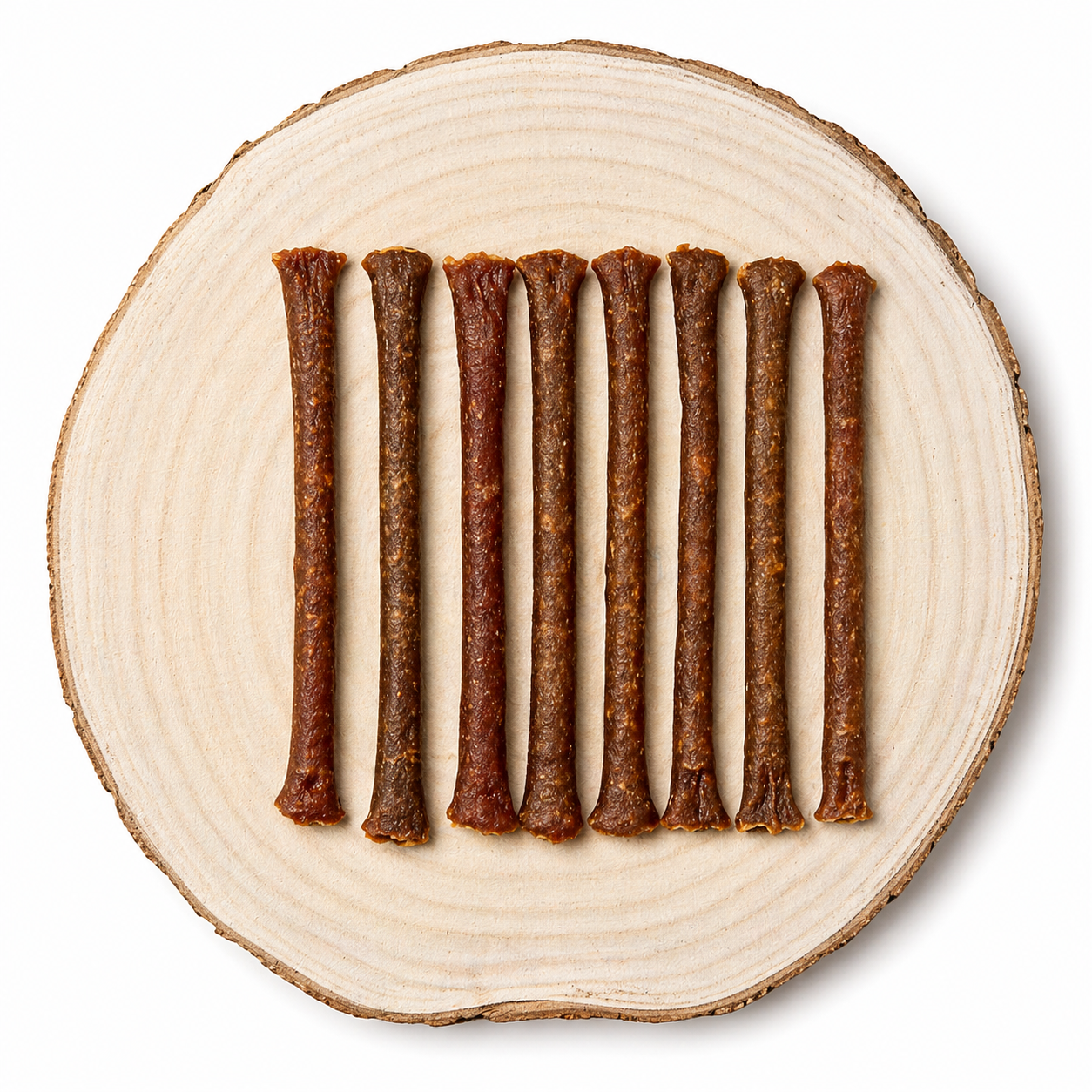 Natural Ostrich meaty dog treat sticks displayed in a row on a natural wooden slice.