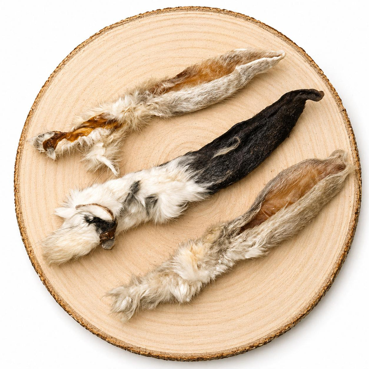 Dried rabbit ears dog treats displayed on wood slice, natural high-protein chew for dogs.