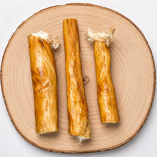 Rabbit skin roll dog treats with natural hair, arranged on a wooden slice, natural chew for dogs

