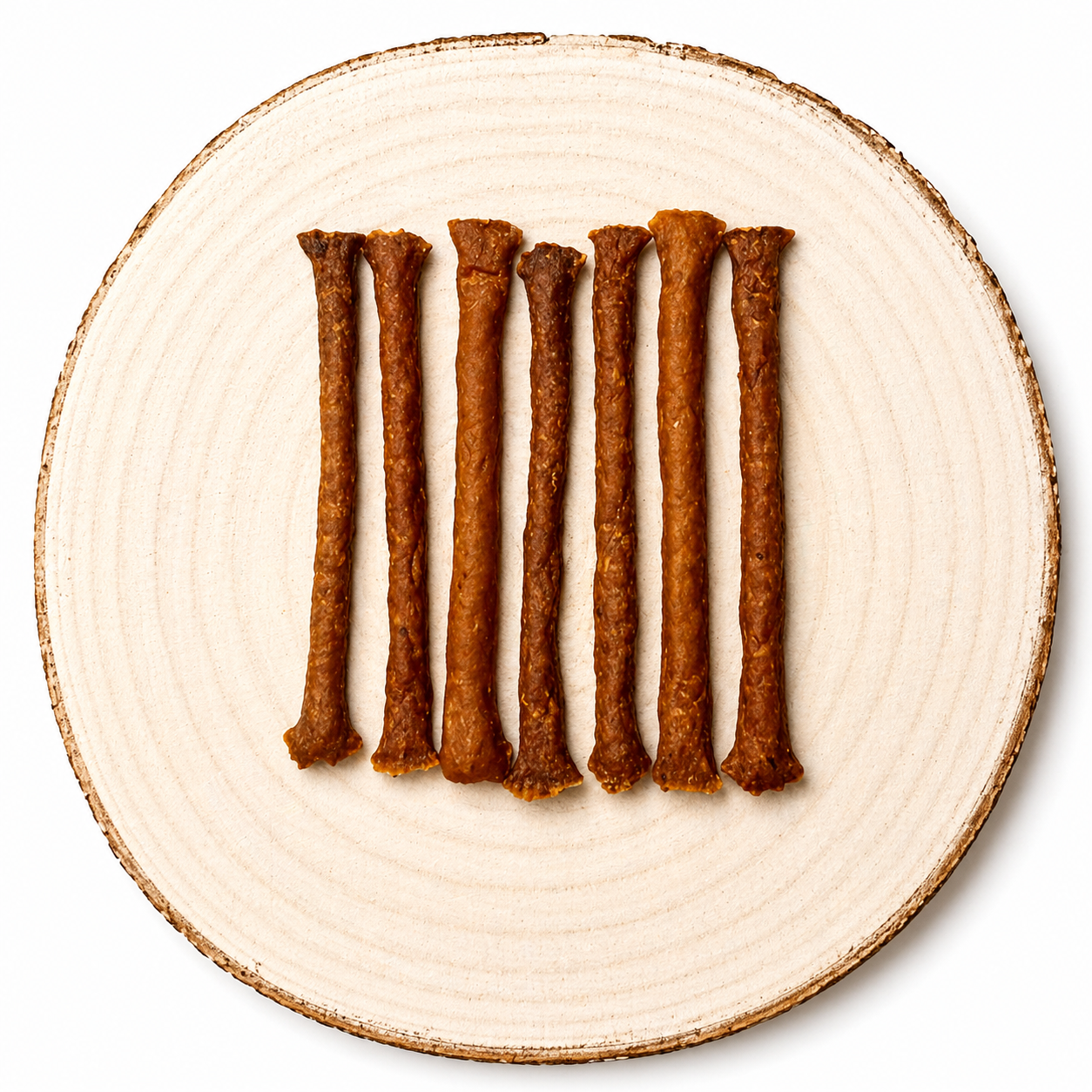 Natural Venison meaty dog treat sticks displayed in a row on a natural wooden slice.
